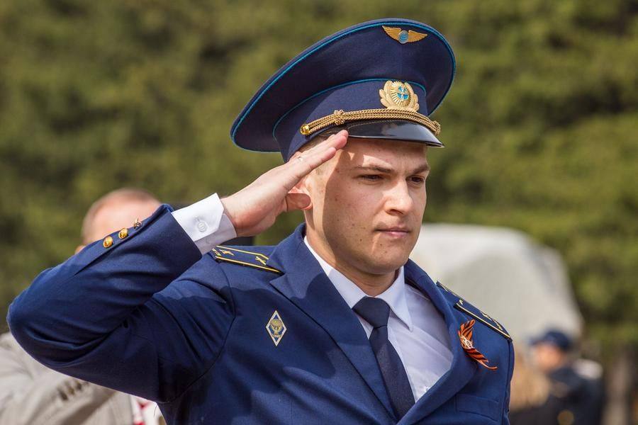 Военные, положив гвоздики, отдают честь павшим