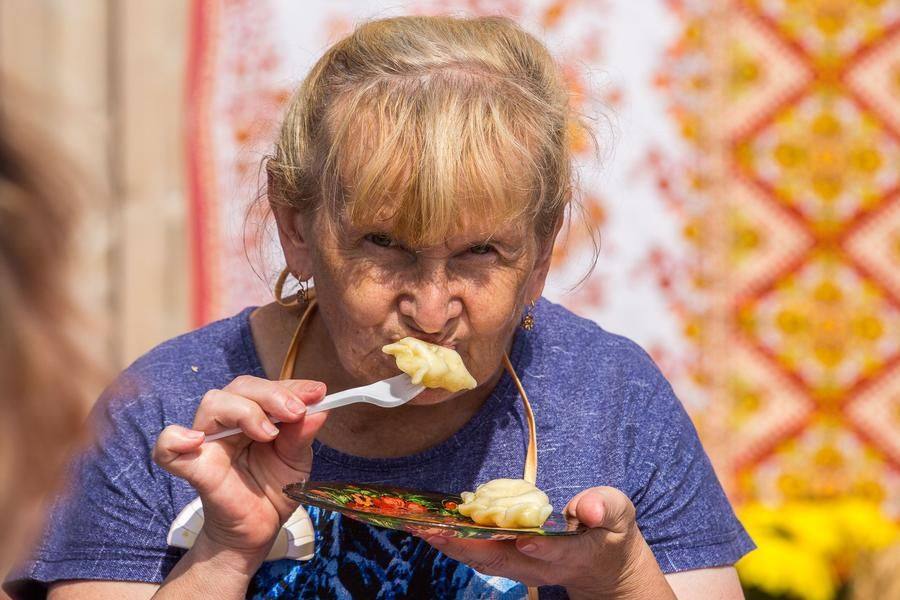 Когда жюри переходит к следующему столу, варениками угощают гостей фестиваля